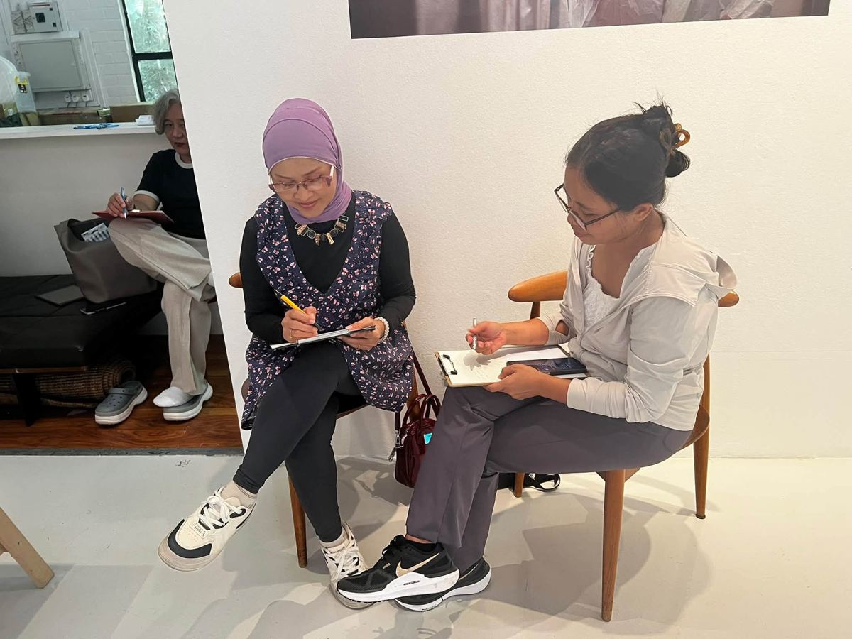 Participant writing at an MWS workshop, [NAME / DESCRIBE]
